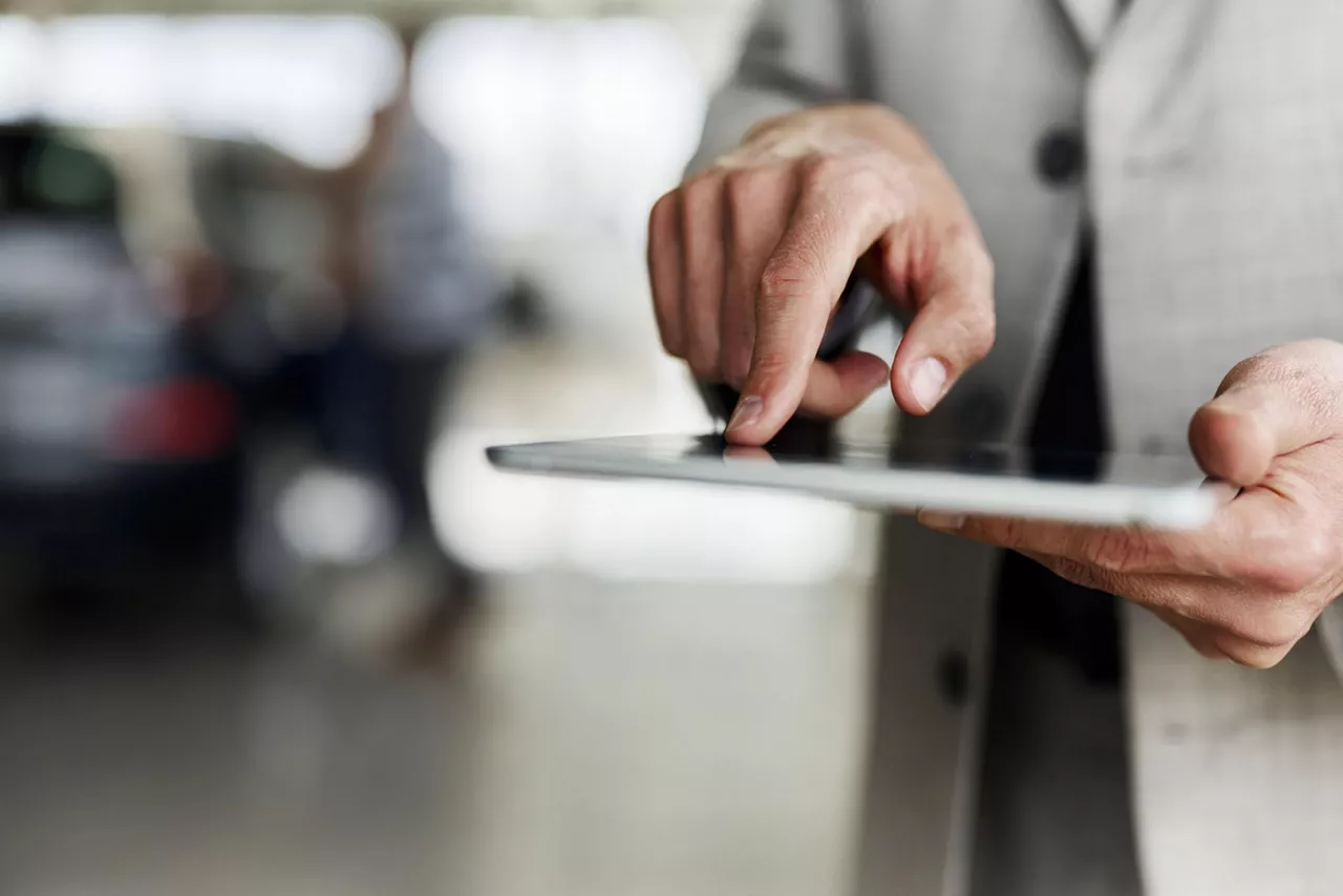 Person in Business-Kleidung tippt auf einem Tablet.