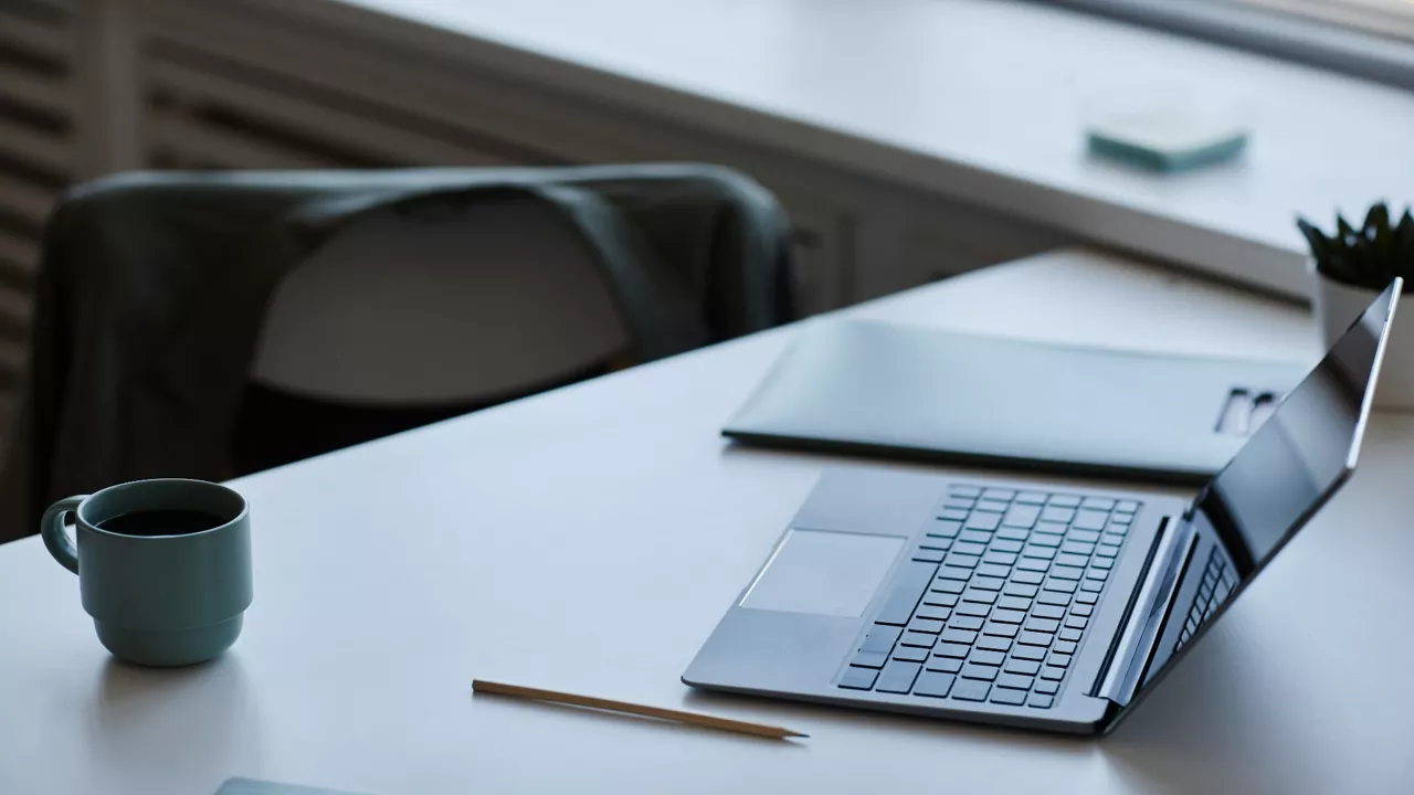 Laptop und Tasse stehen auf Tisch