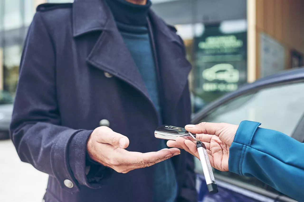 übergabe-eines-autoschlüssels-vor-der-station-von-vw-fs-rent-a-car