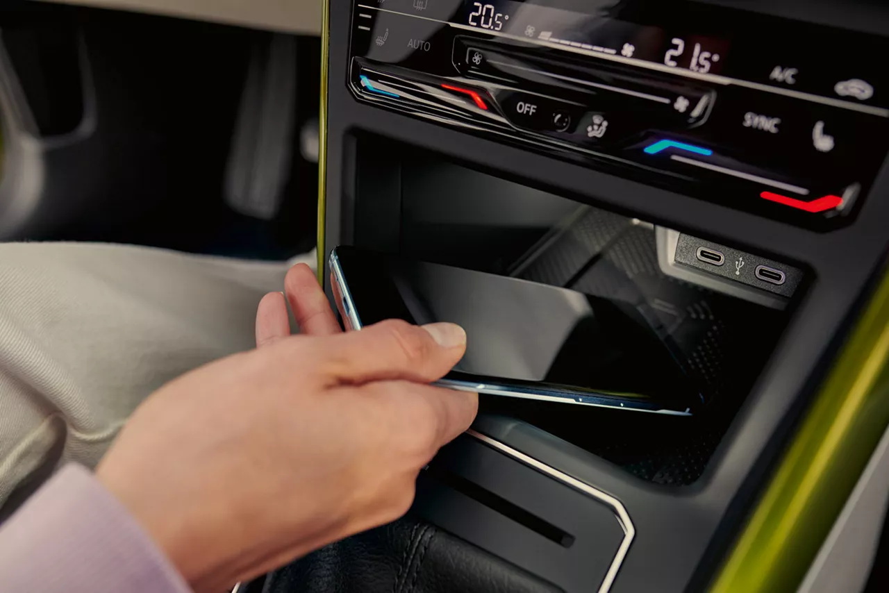 Smartphone wird für das Laden in das Ablagefach der Mittelkonsole eines Autos gelegt
