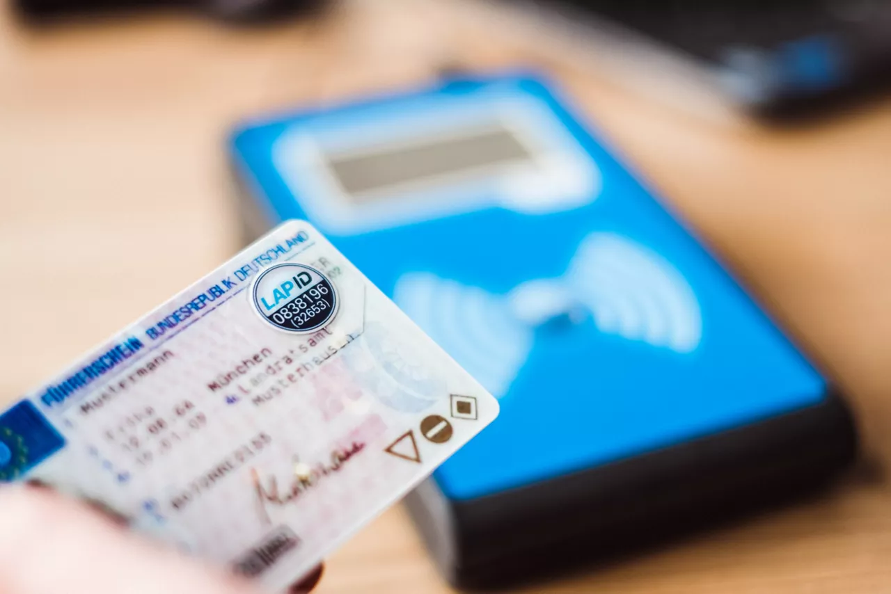 Zwei Männer führen eine elektronische Führerscheinkontrolle durch.