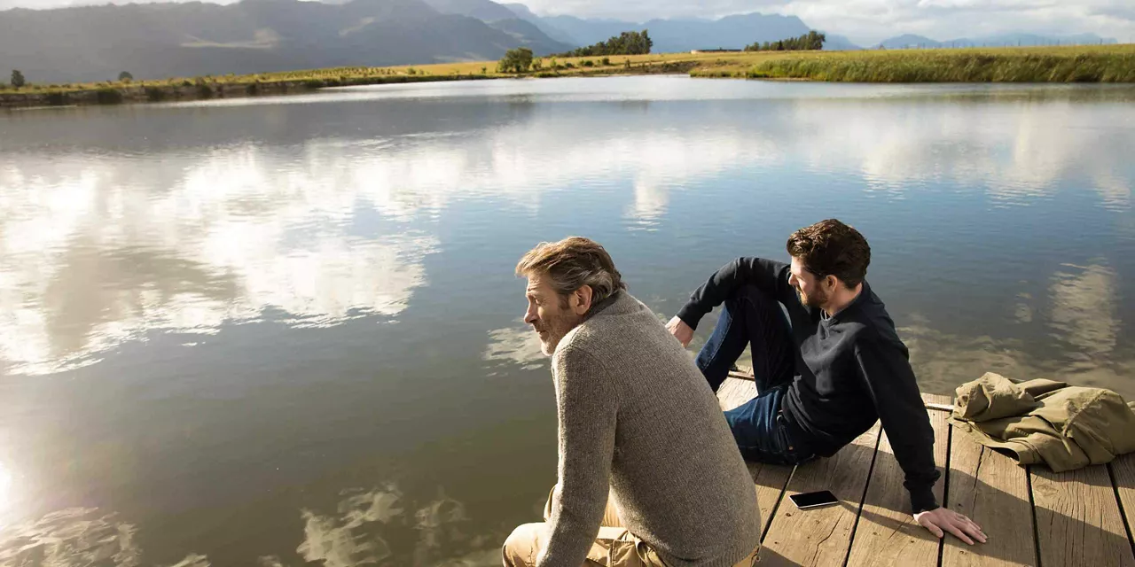 Männer sitzen am See