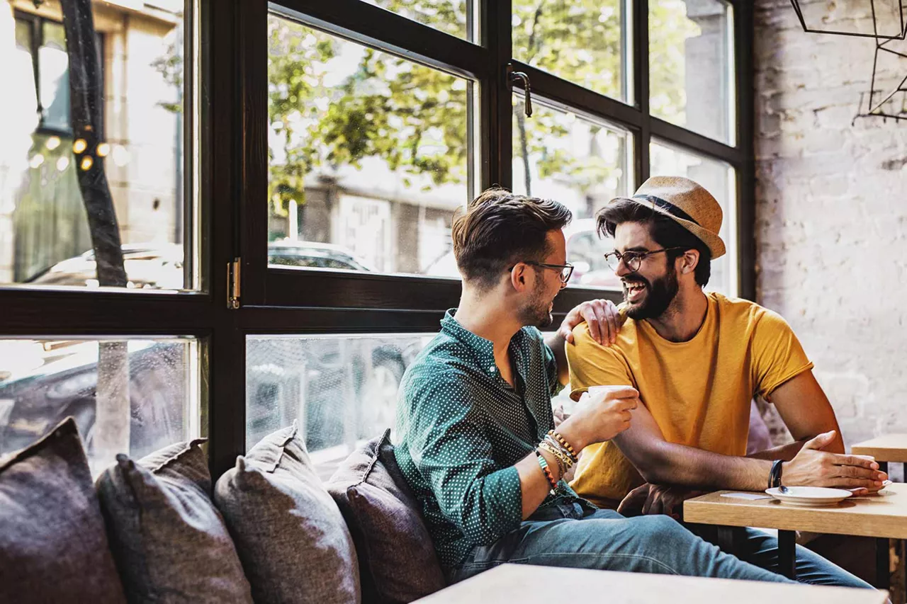 zwei-miteinander-vertraute-lachende-personen-sitzen-in-einem-cafe