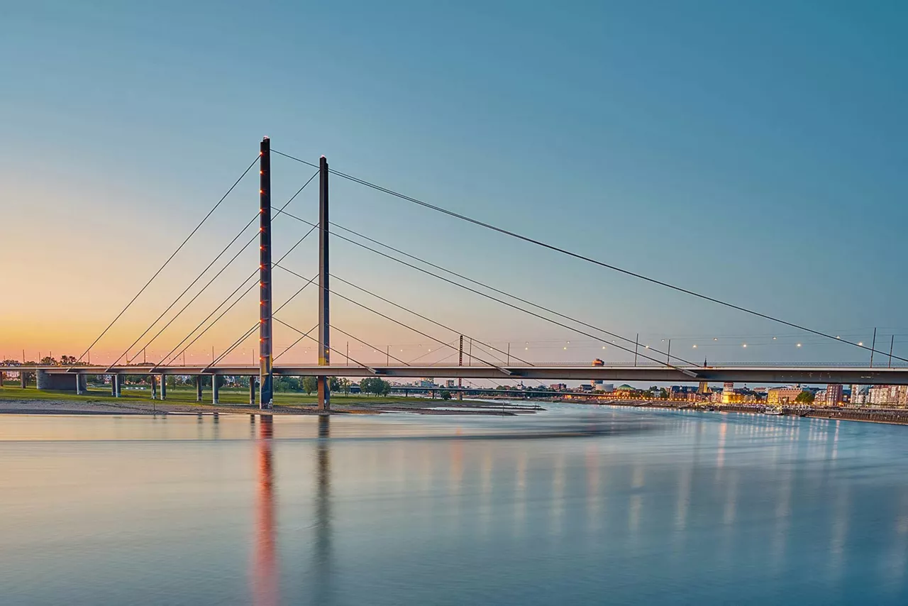 futuristische-rote-brücke-am-rheinufer-bei-dämmerung