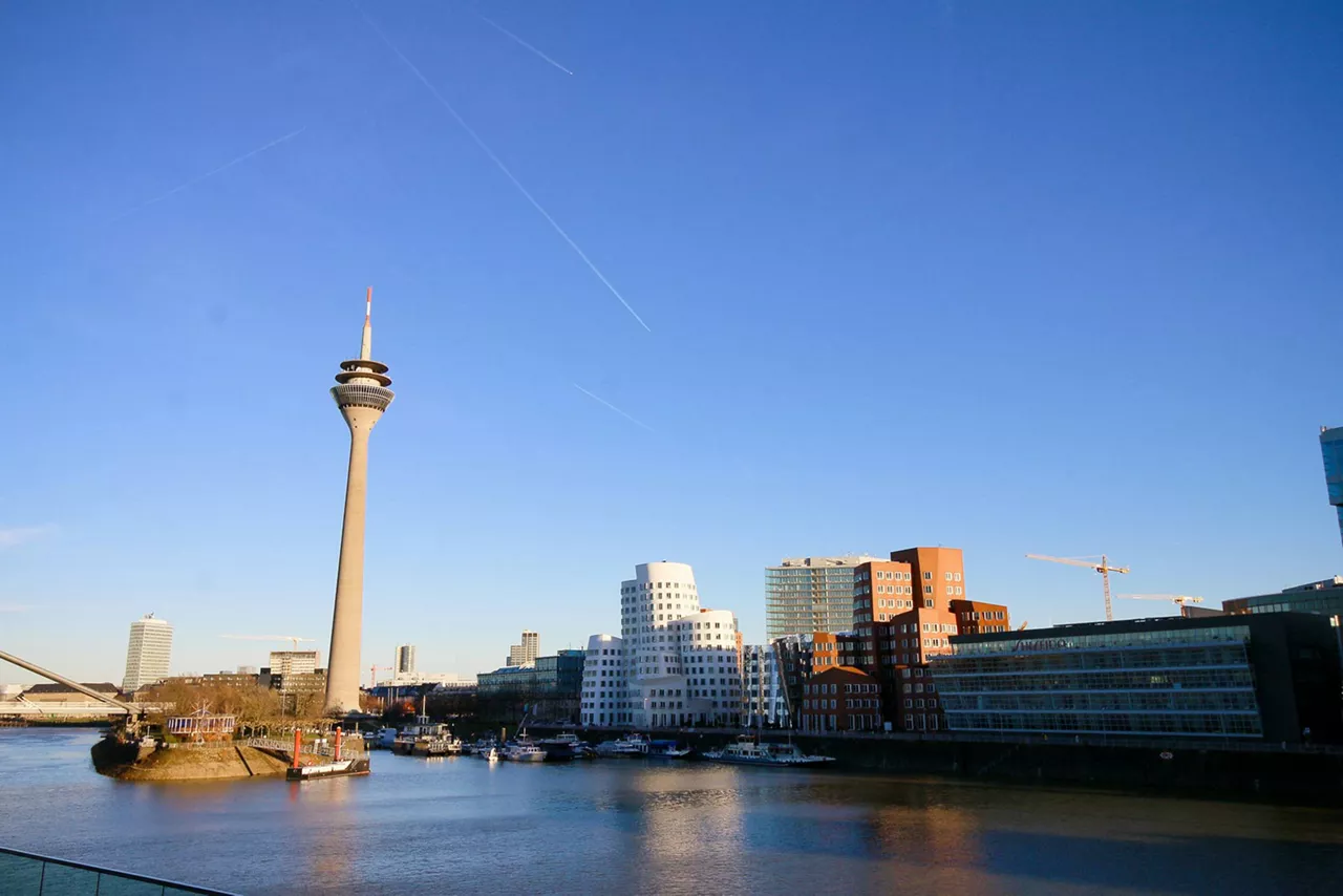 fernsehturm-und-futurische-gebaeude-am-rheinufer-bei-blauem-himmel