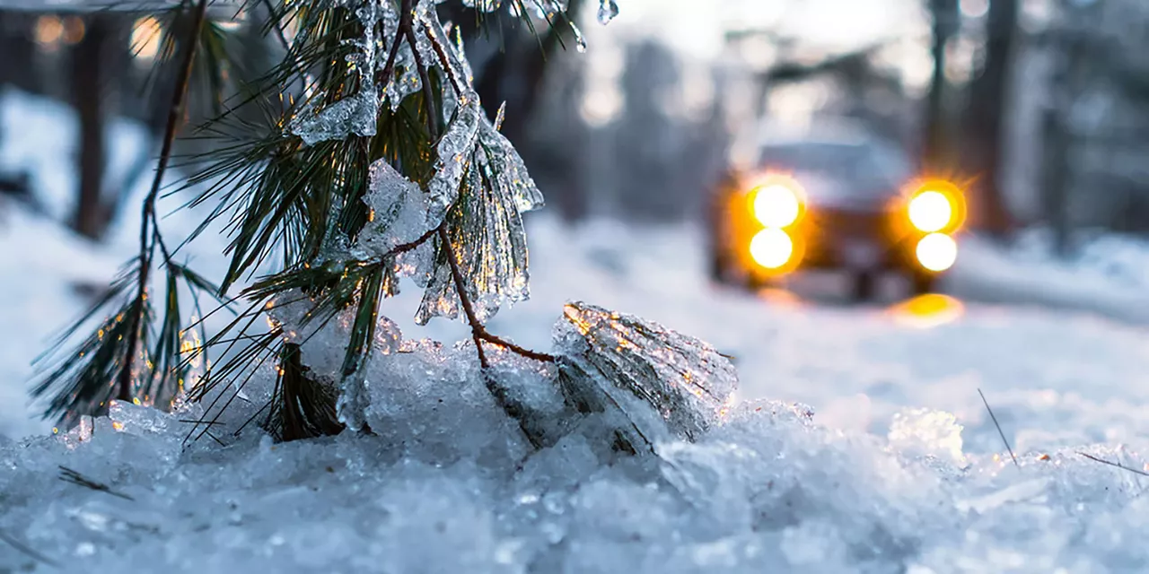 auto-mit-eingeschalteten-scheinwerfern-fährt-durch-schneelandschaft