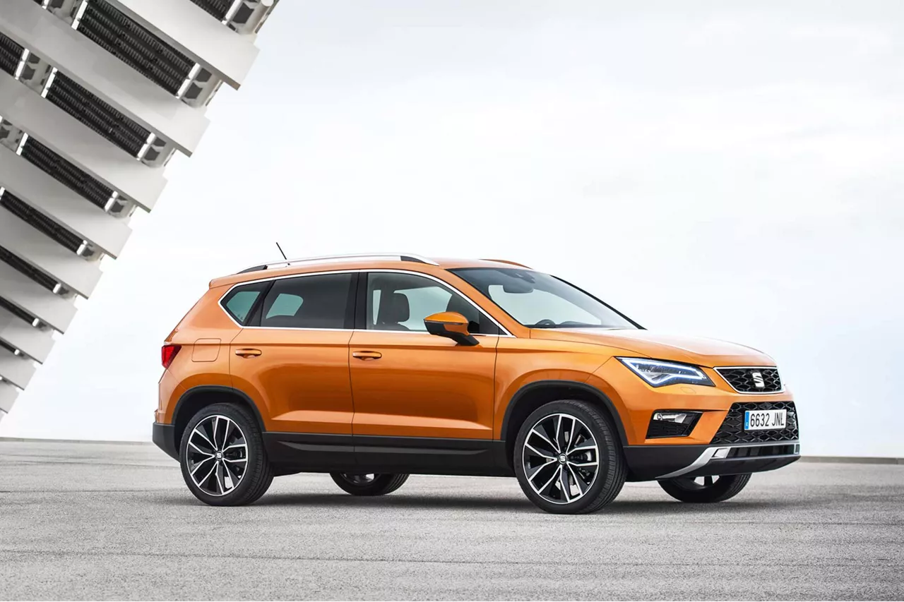 orangener-seat-ateca-steht-auf-asphaltiertem-platz