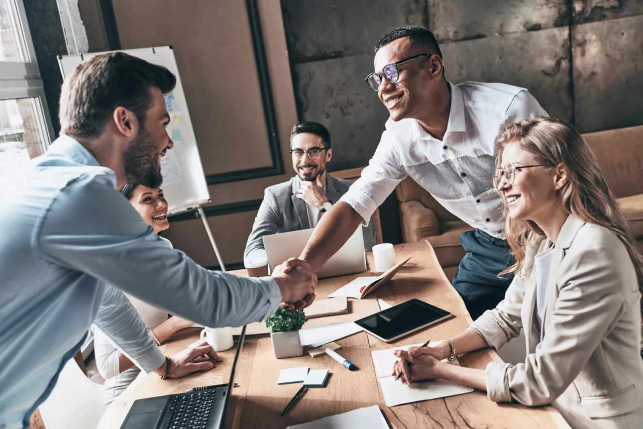 Networking mit Icebreaker-Fragen im Meeting zwischen fünf Kollegen