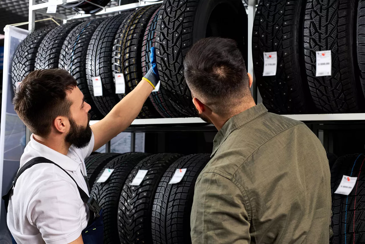 Zwei Männer stehen vor einem Regal mit Reifen.