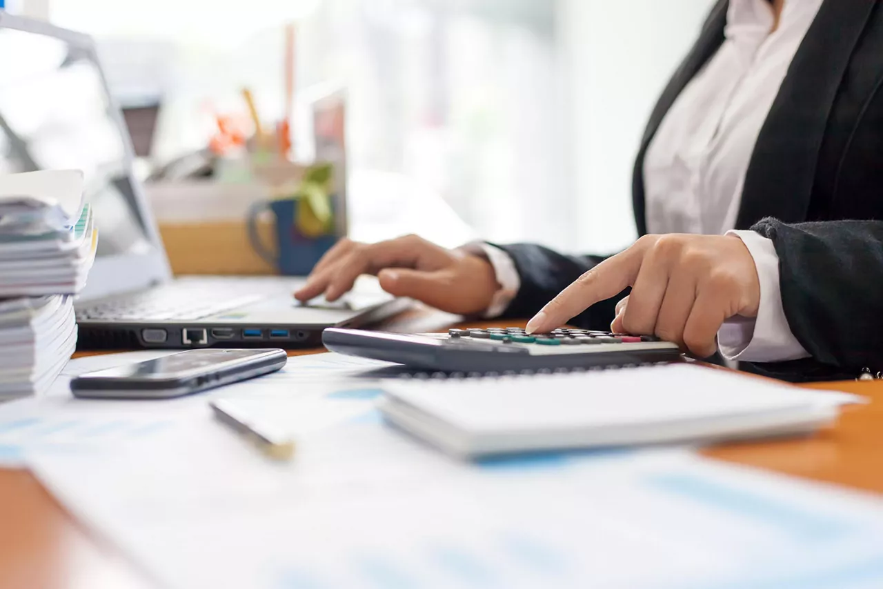 Frau rechnet mit einem Taschenrechner
