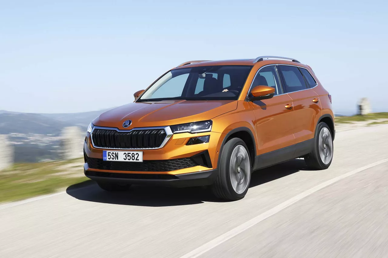 orangener-skoda-karoq-auf-asphaltierter-strasse 