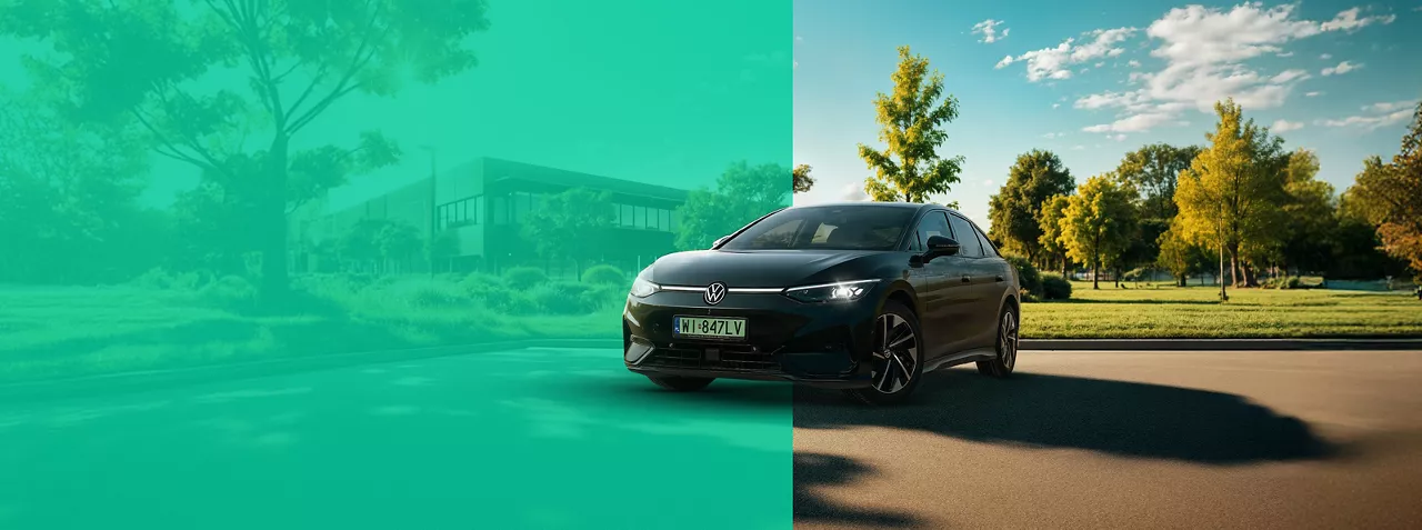 Czarny elektryczny Volkswagen ID. 7 z zieloną tablicą rejestracyjną. Samochód zaparkowany jest przodem do odbiorcy, na parkingu przy nowoczesnym budynku przypominającym elewację szkoły, uniwersytetu lub biurowca. Wokół przyroda: zielone krzewy i drzewa.