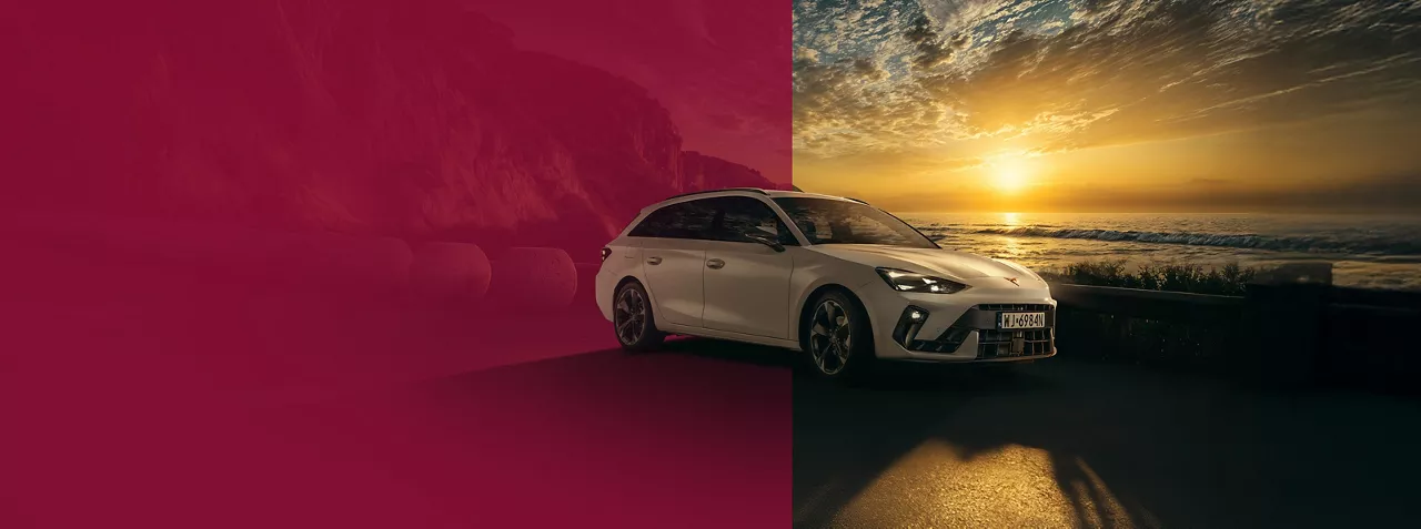 CUPRA Leon w białym kolorze stoi zaparkowana na widokowej drodze oddzielającej góry od morza. Sceneria rozświetlona jest blaskiem zachodzącego słońca na horyzoncie.