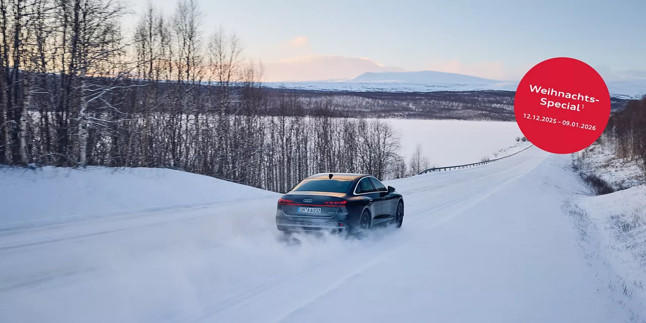 Ein schwarzer Audi in demand rent Mitwagen fährt auf einer schneebedeckten Landstrasse durch eine Verschneite Landschaft. Oben rechts steht auf einem roten Störer in weisser Schrift: Weihnachts-Special vom 12.122025 - 09.01.2026