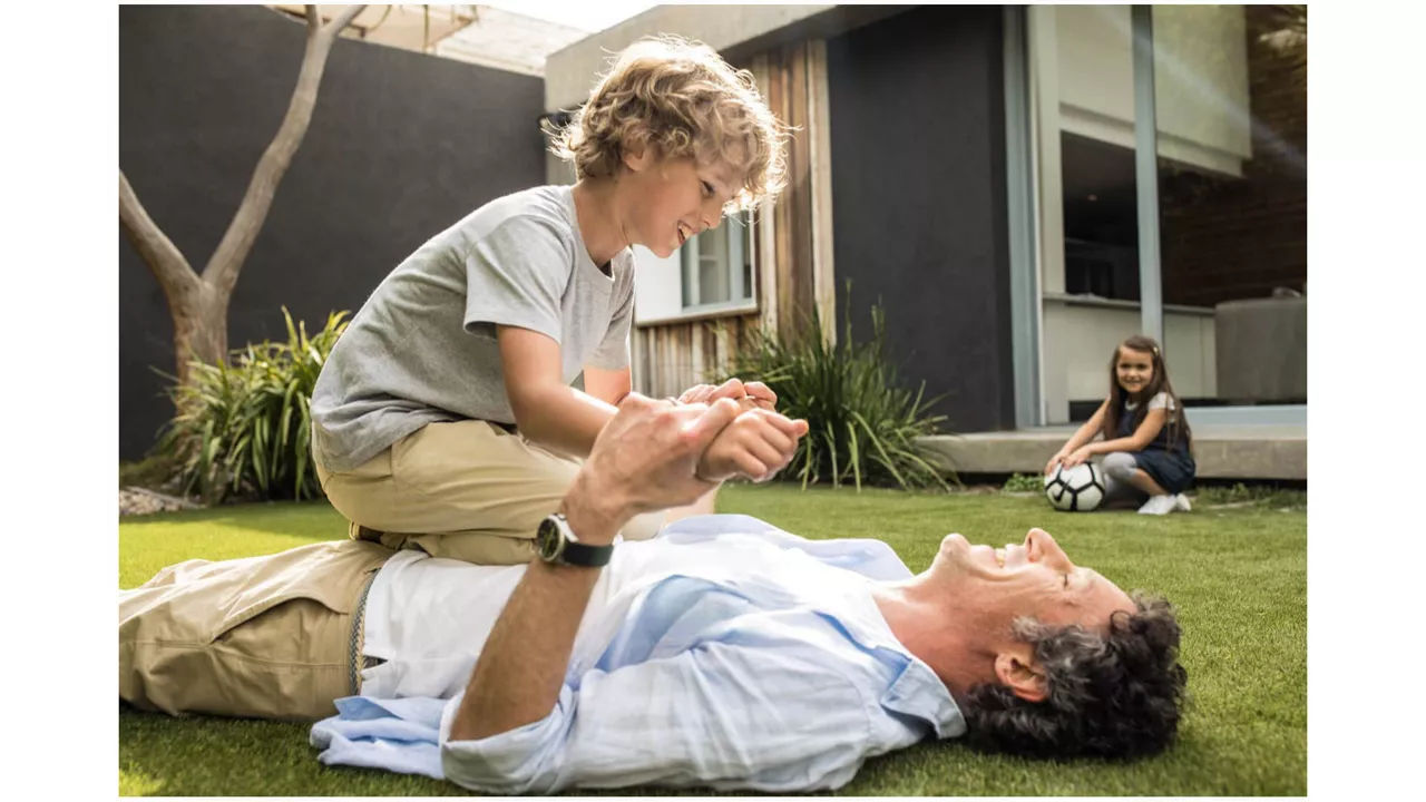 Père qui joue avec son fils dans le jardin