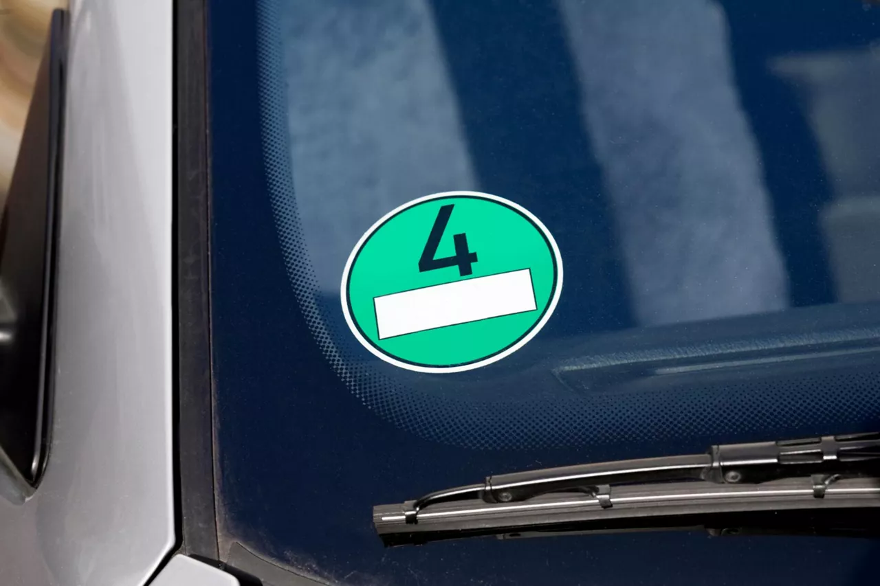 Grüne Umweltplakette klebt auf der Windschutzscheibe eines Autos