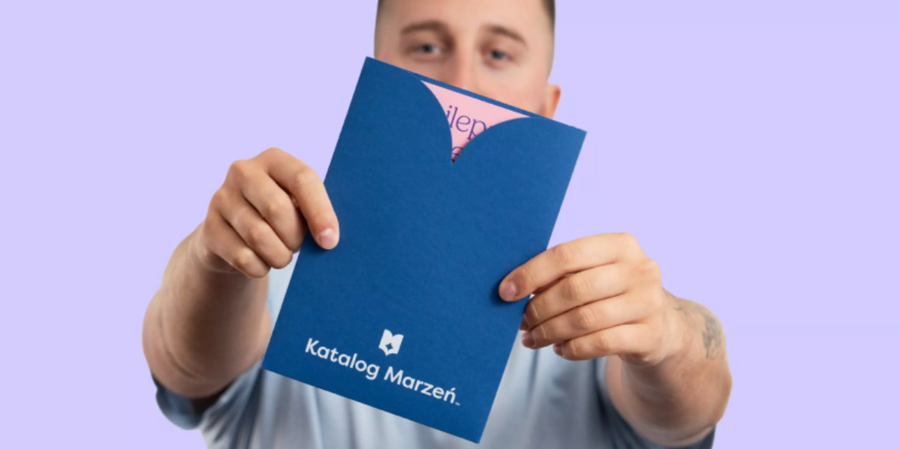 Zdjęcie przedstawia mężczyznę z kuponem do Katalogu Marzeń.