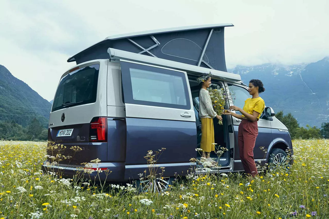 frau-und-kind-am-vw-california-mit-aufstelldach-auf-blumenwiese