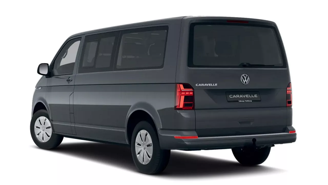 Dunkelgrauer VW Caravelle steht schräg seitlich von hinten vor weißem Hintergrund