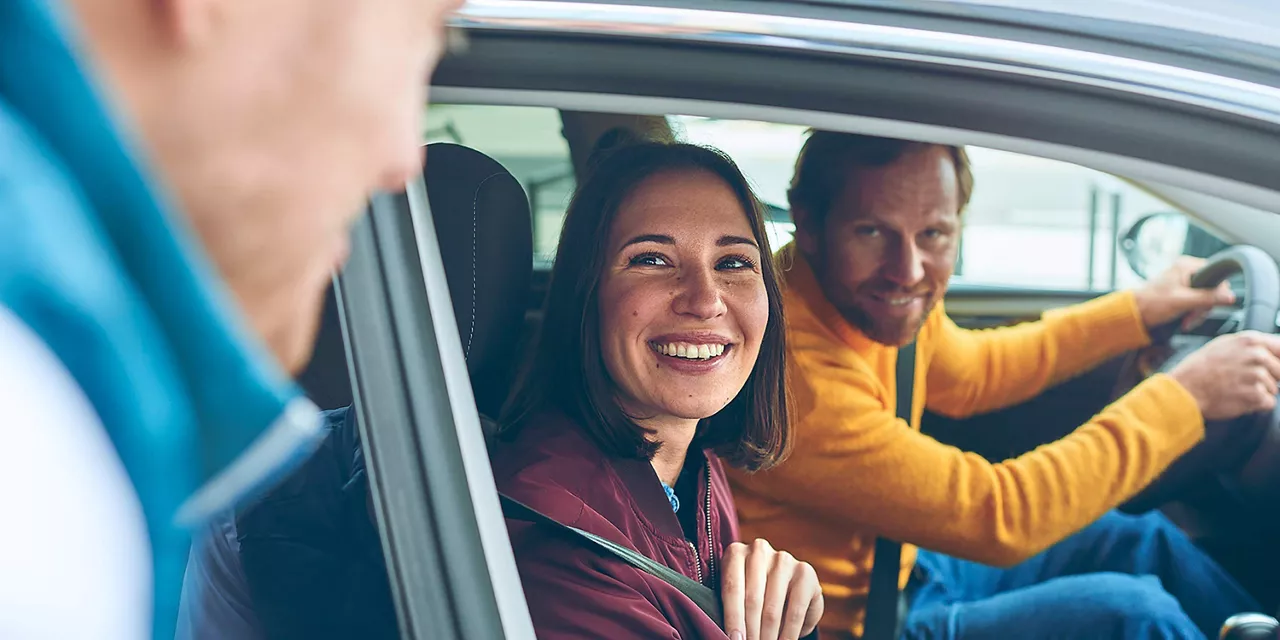 Frau mietet bei einer Rent-a-Car Mitarbeiterin ein Auto.