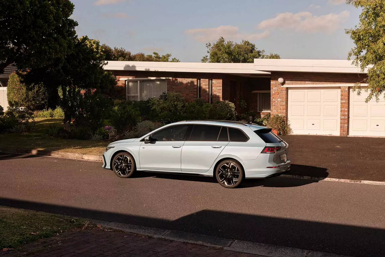 weisser-vw-golf-variant-steht-seitlich-vor-einem-familienhaus-an-der-strasse