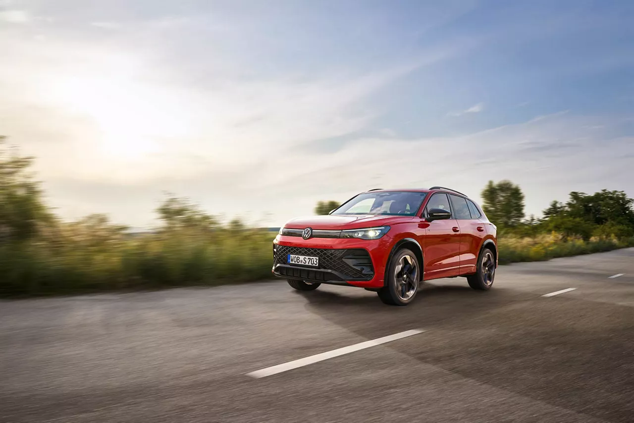 roter-vw-tiguan-fährt-bei-sonnenschein-auf-einer-strasse