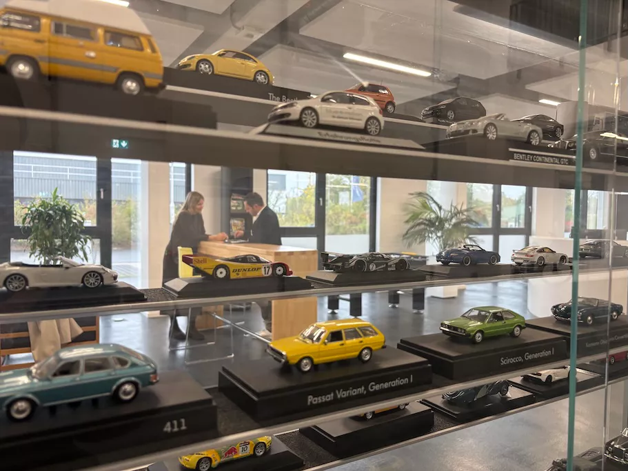 Unterschiedliche VW-Modelle in einer Vitrine, DWC-Leiter Marc Schwechheimer im Hintergrund