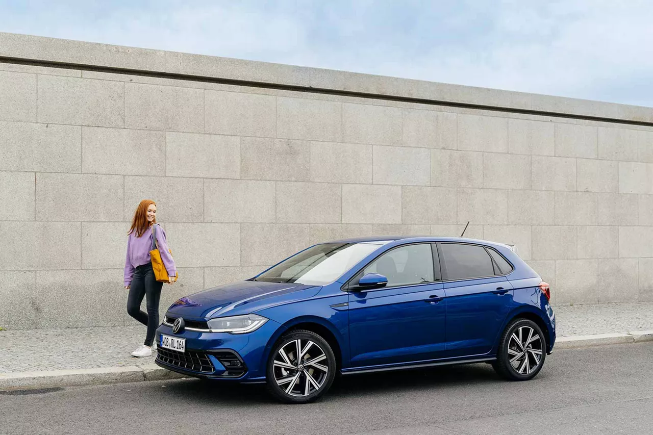 Blauer VW Polo als Mietwagen am Straßenrand in urbaner Umgebung