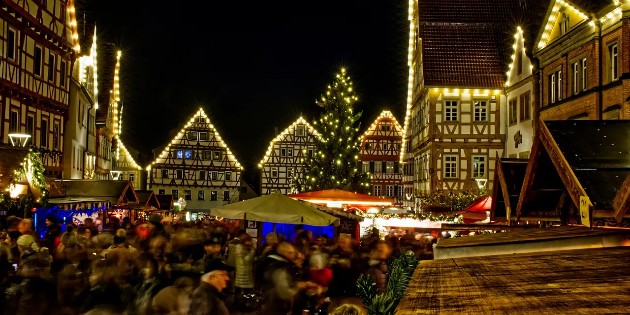 beleuchteter-weihnachtsmarkt-mit-vielen-menschen-und-ständen